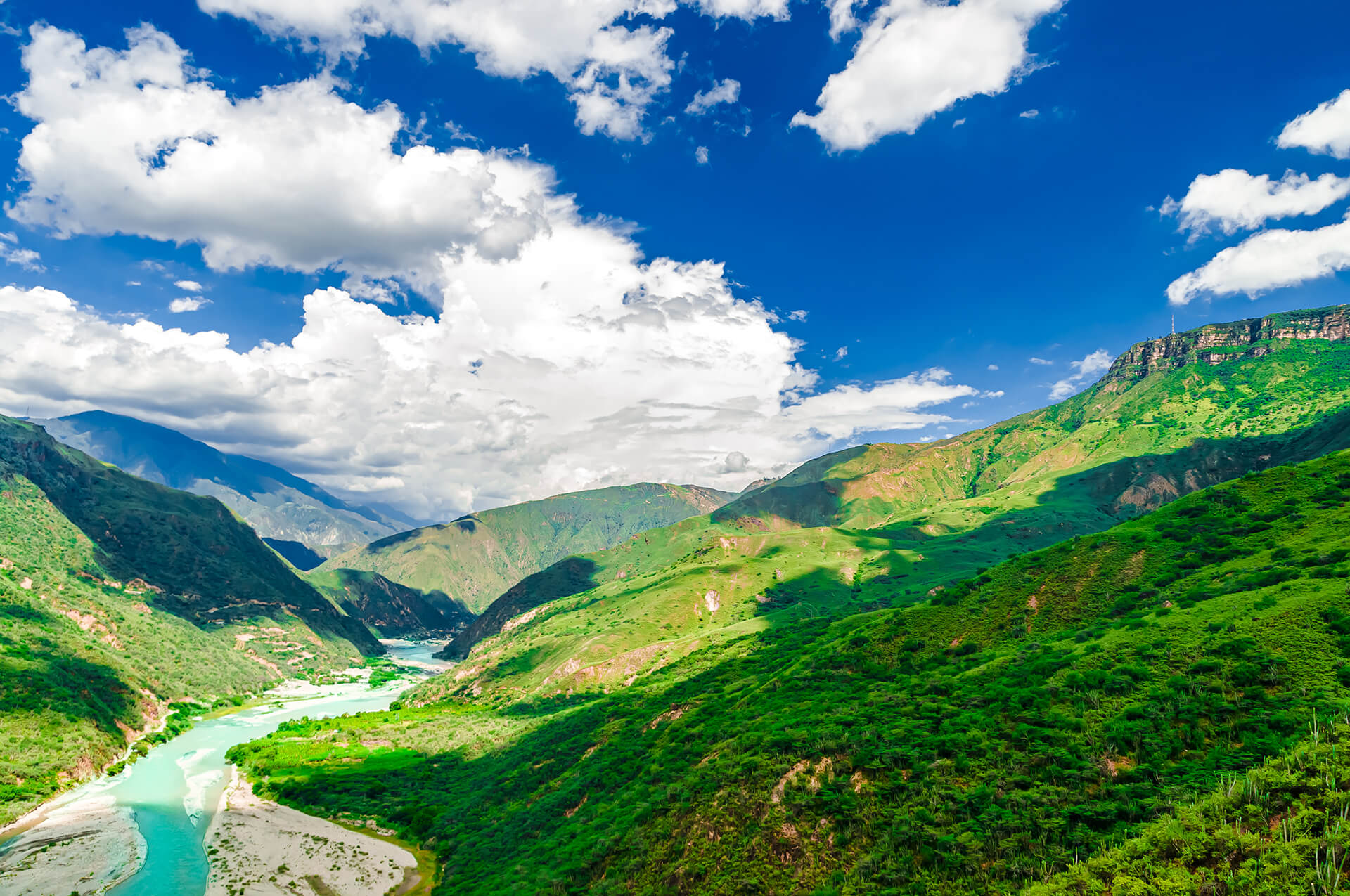 Blue sky with clouds over rolling mountains