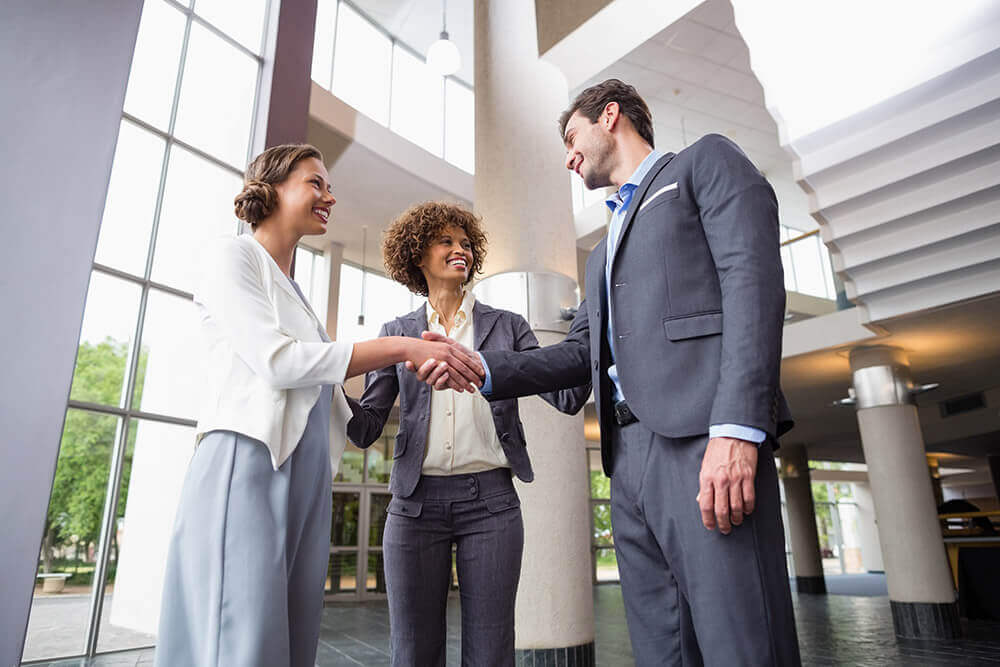 Three professionals greet each other